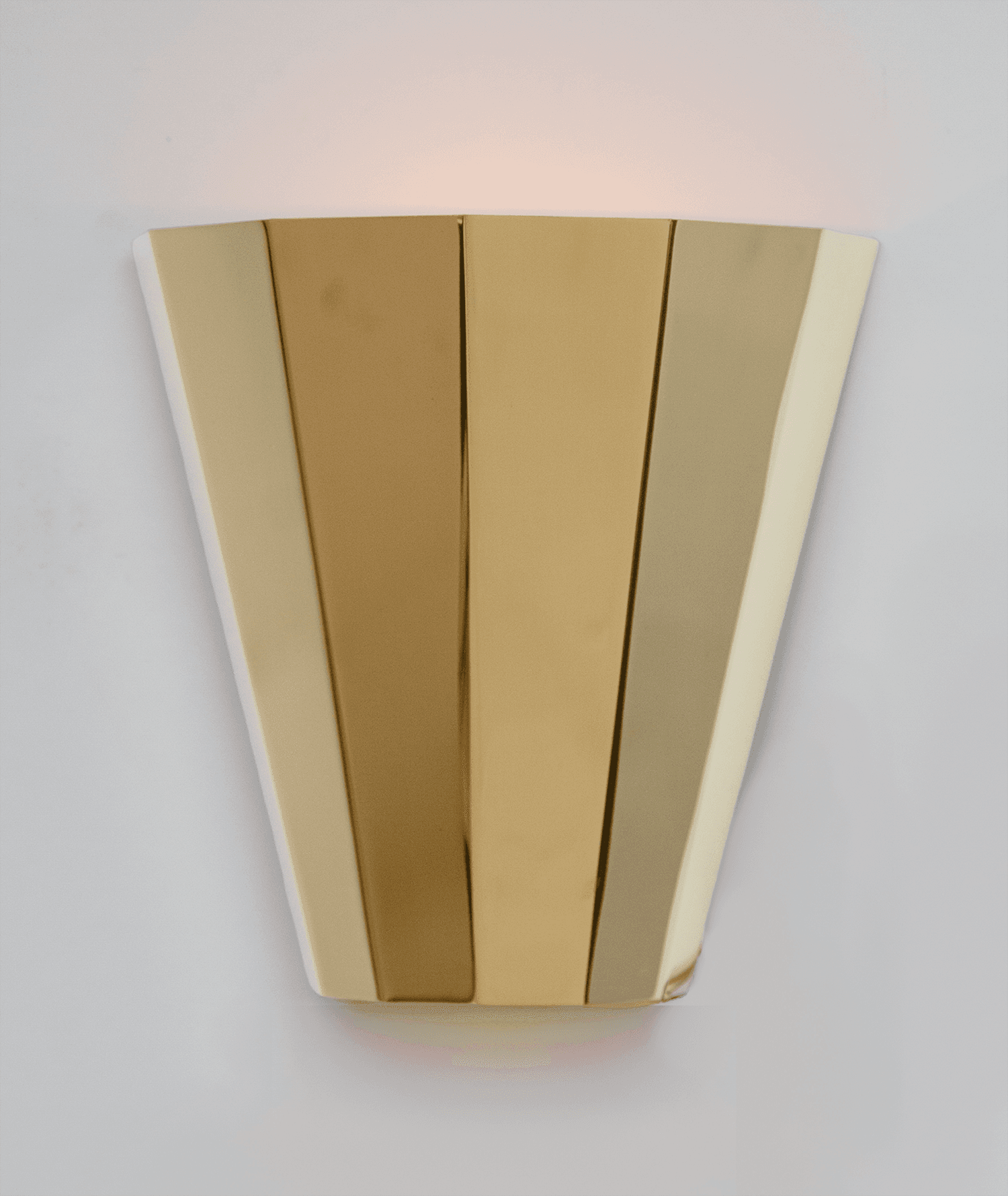 A wall sconce made to look like folded paper, hung on a white wall.