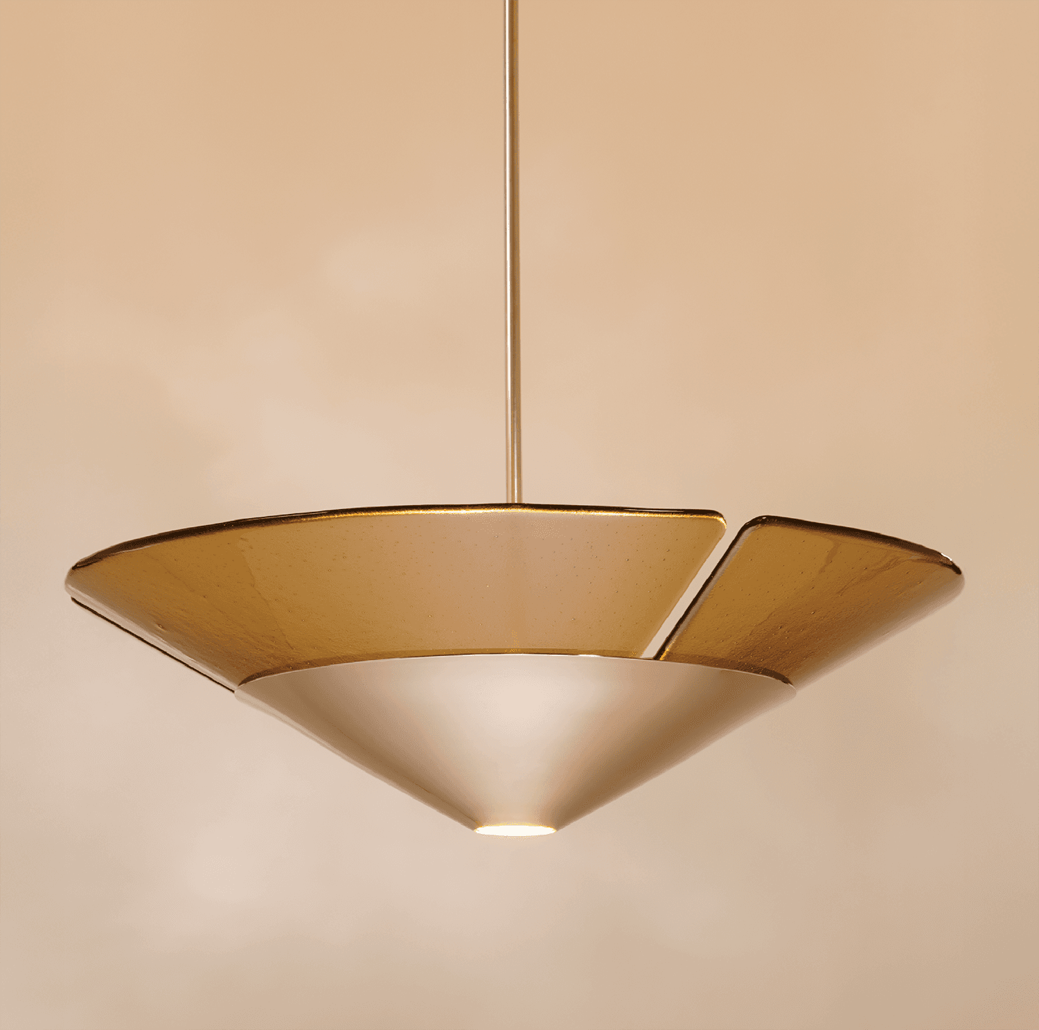 A triangular light fixture made of amber glass.