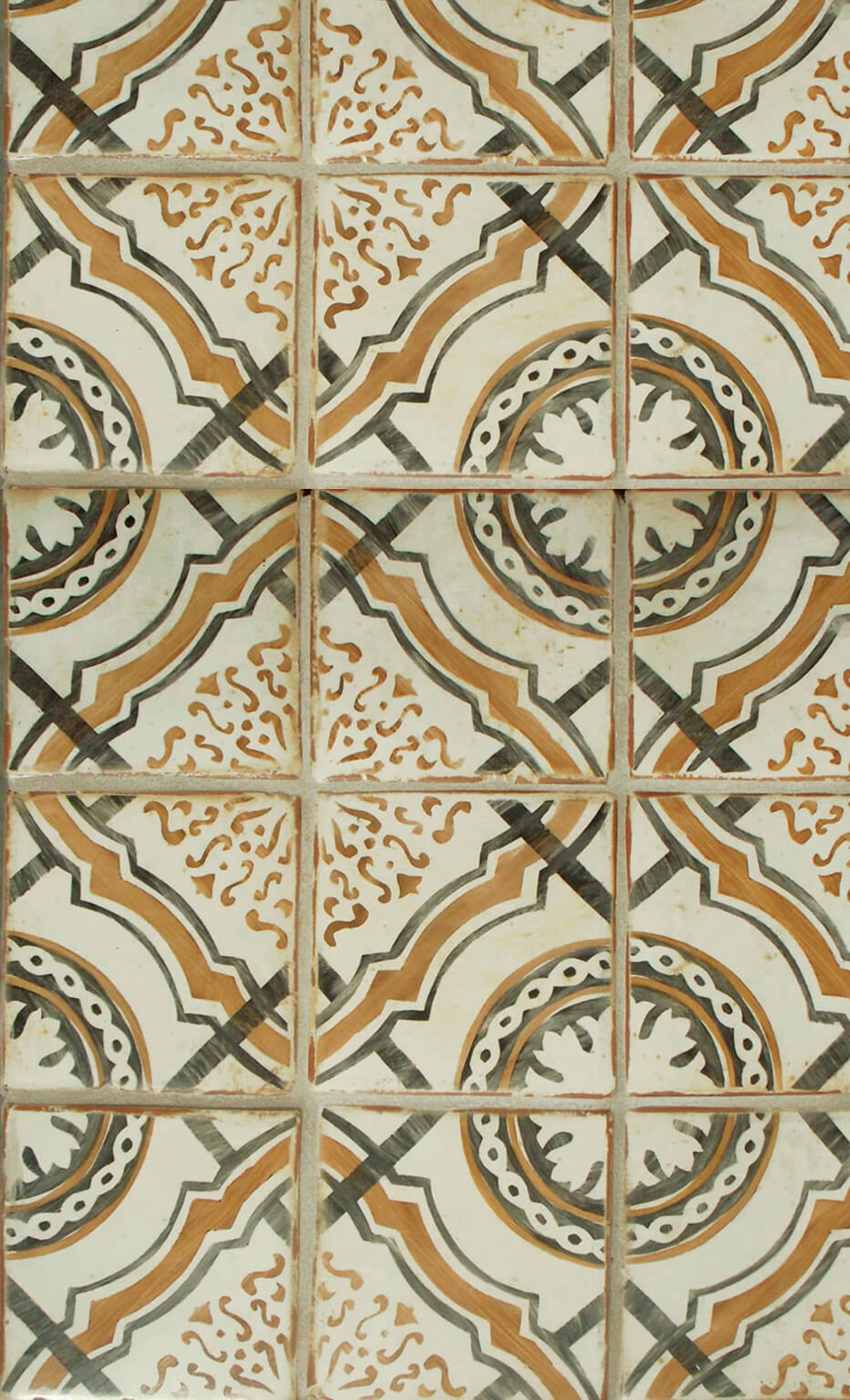 Tabarka Studio’s Polanco tile featuring a hand-painted, geometric pattern in earthy green and terracotta tones.