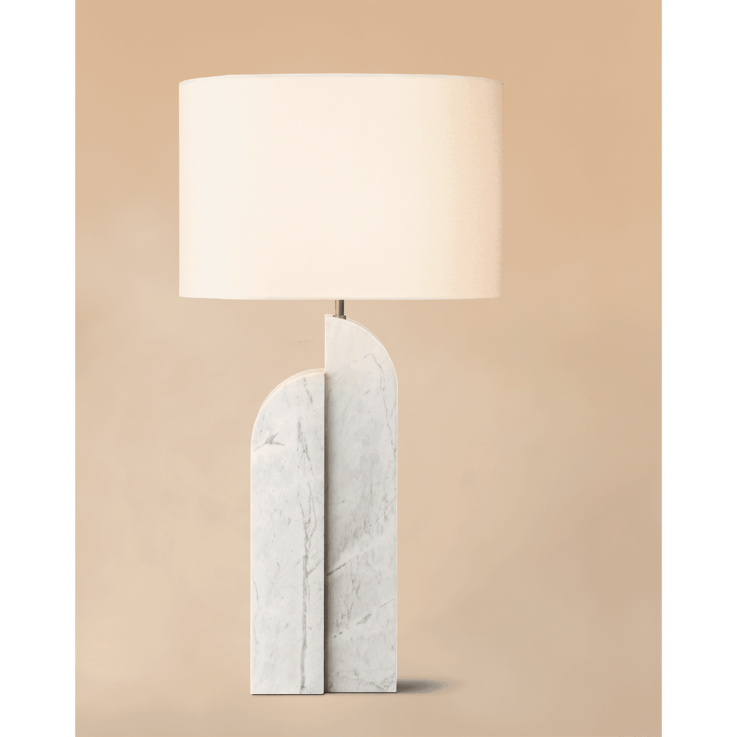 A table lamp with a marble base made of two columns of different heights with a lampshade.