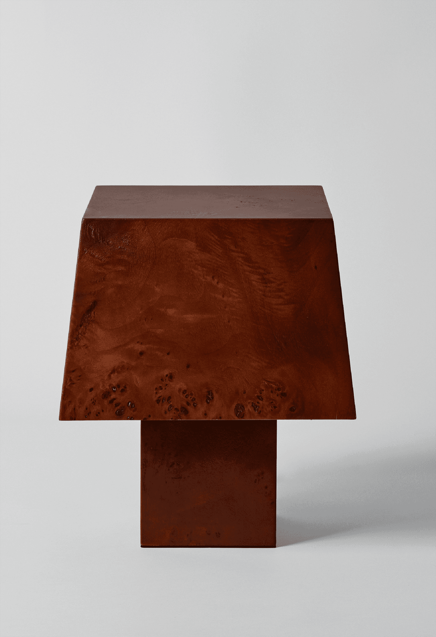 A table lamp with a dark, square base leading up to a matching, wider lampshade.