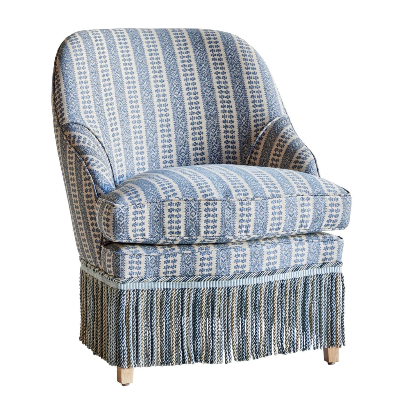 Blue upholstered chair with fringe skirt in patterned Patmos fabric by Susan Deliss.