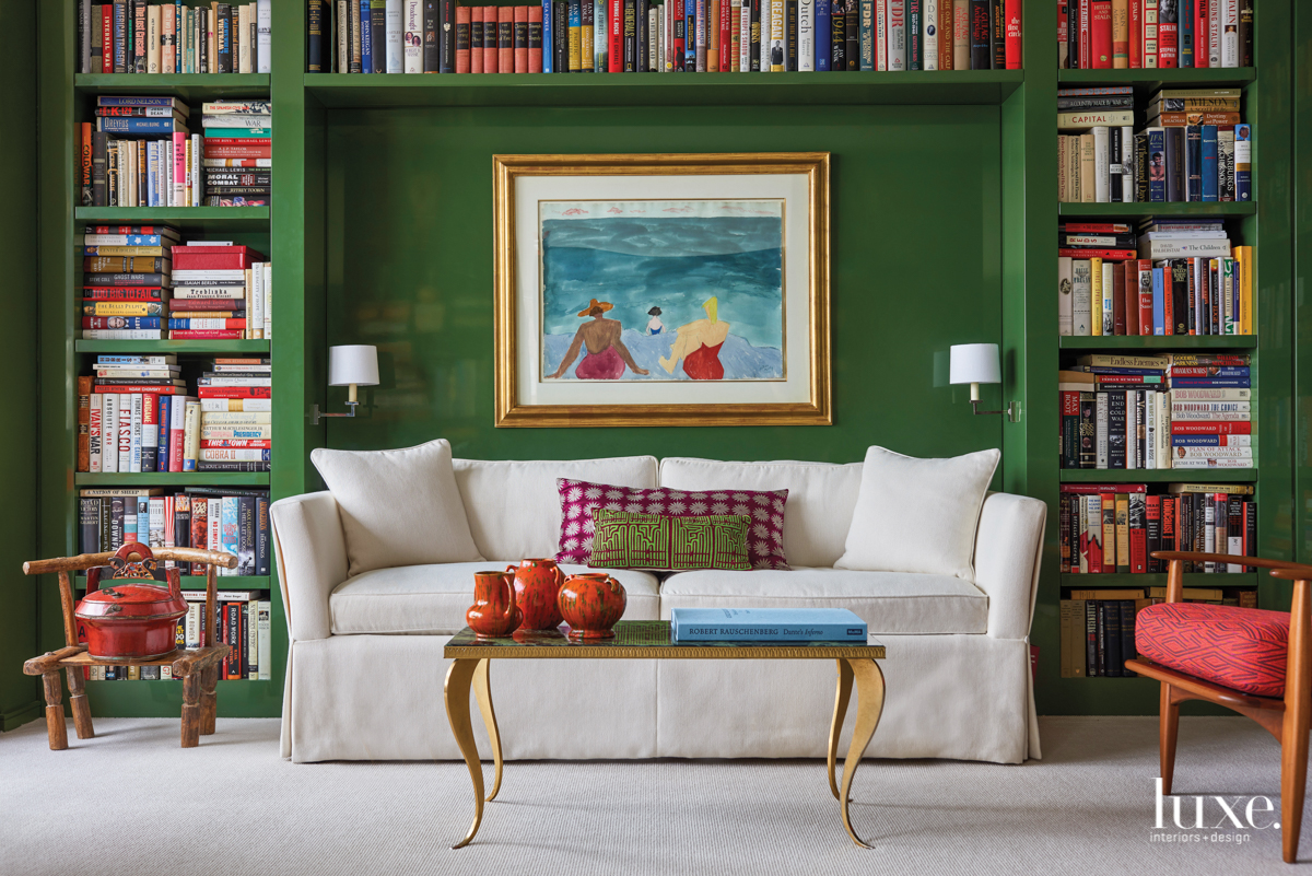 green study office with bookshelves and neutral couch