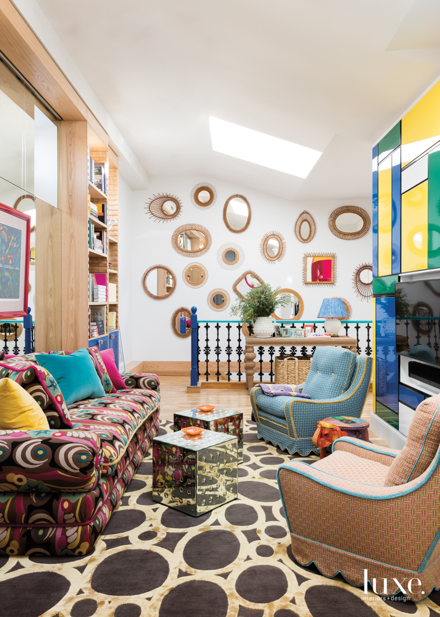 colorful room with maximalist interior design and wall of mirrors by the stairs