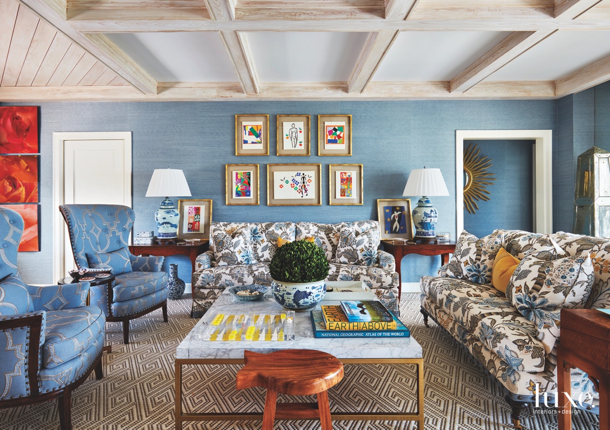 room with blue walls and chairs with white table and patterned couch in front by FASCA, Inc.
