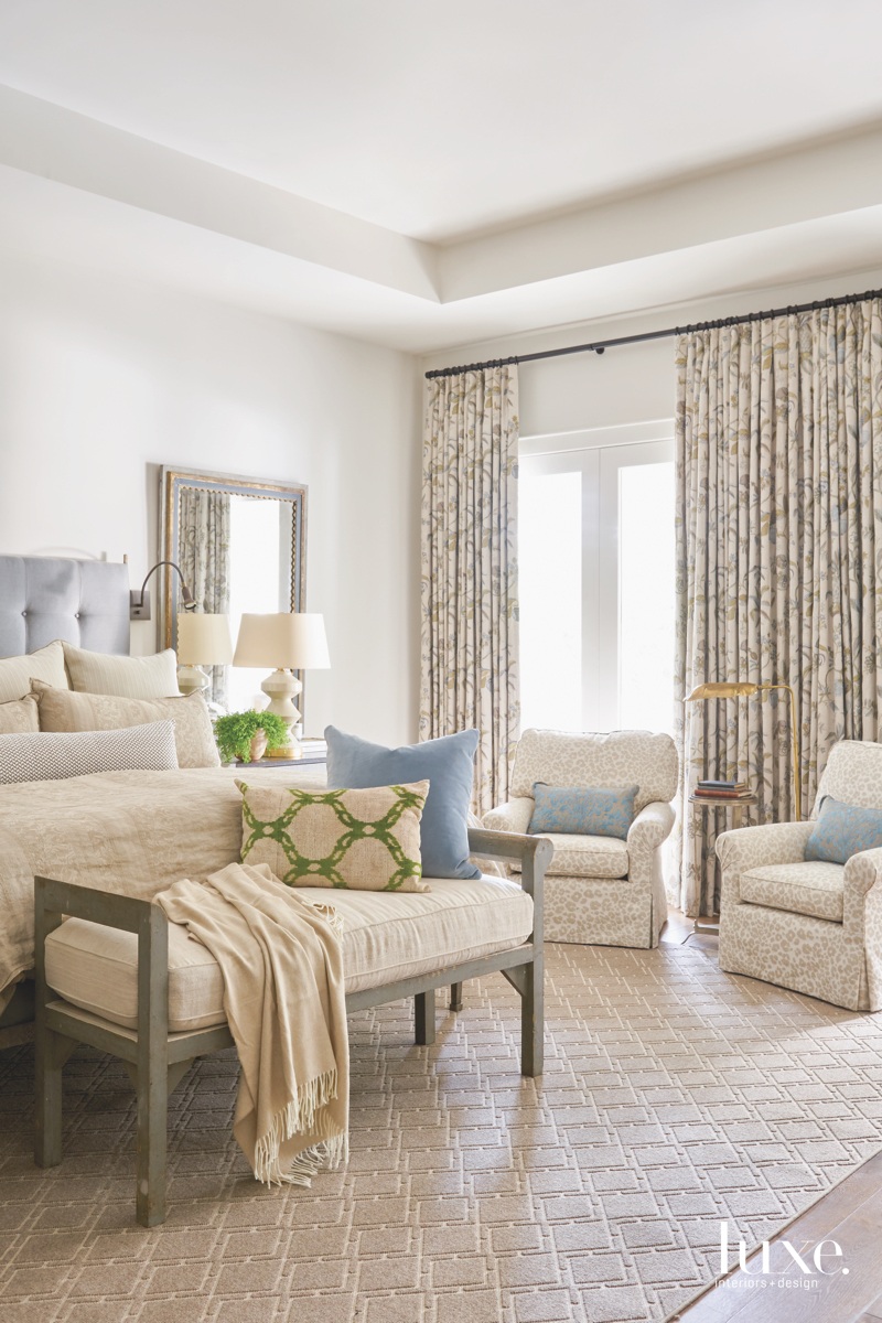 transitional bedroom neutral rug armchairs