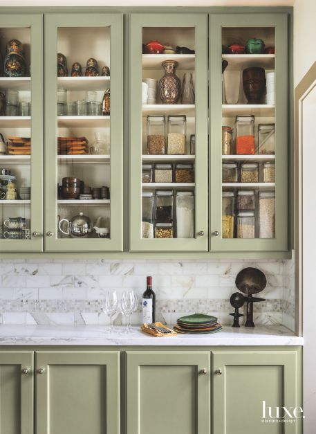 light green cabinets filled with pantry essentials and a white countertop