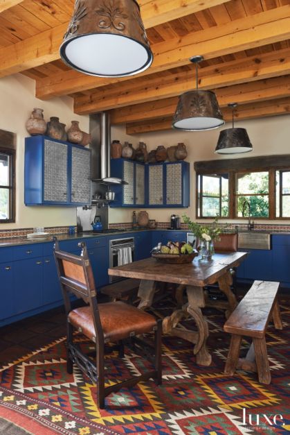 colorful dining room with dark blue cabinets and wooden beams in ceiling