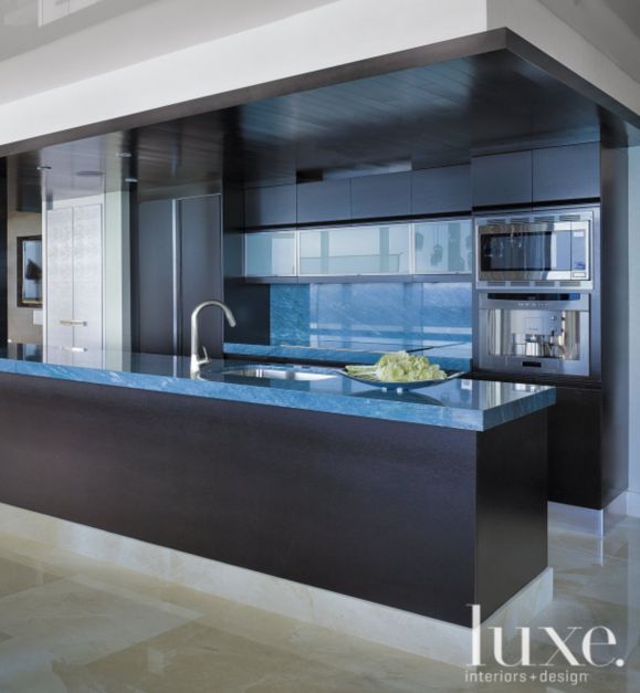 dark black cabinets and ceiling along with frosty blue countertops