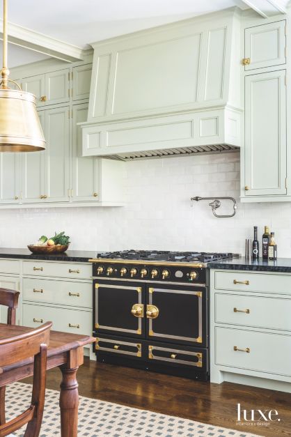 mint green cabinetry and range and a black and gold stove range