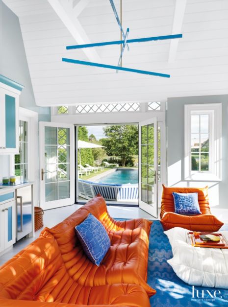 bright orange chairs in front of blue and white cabinetry in a pool house