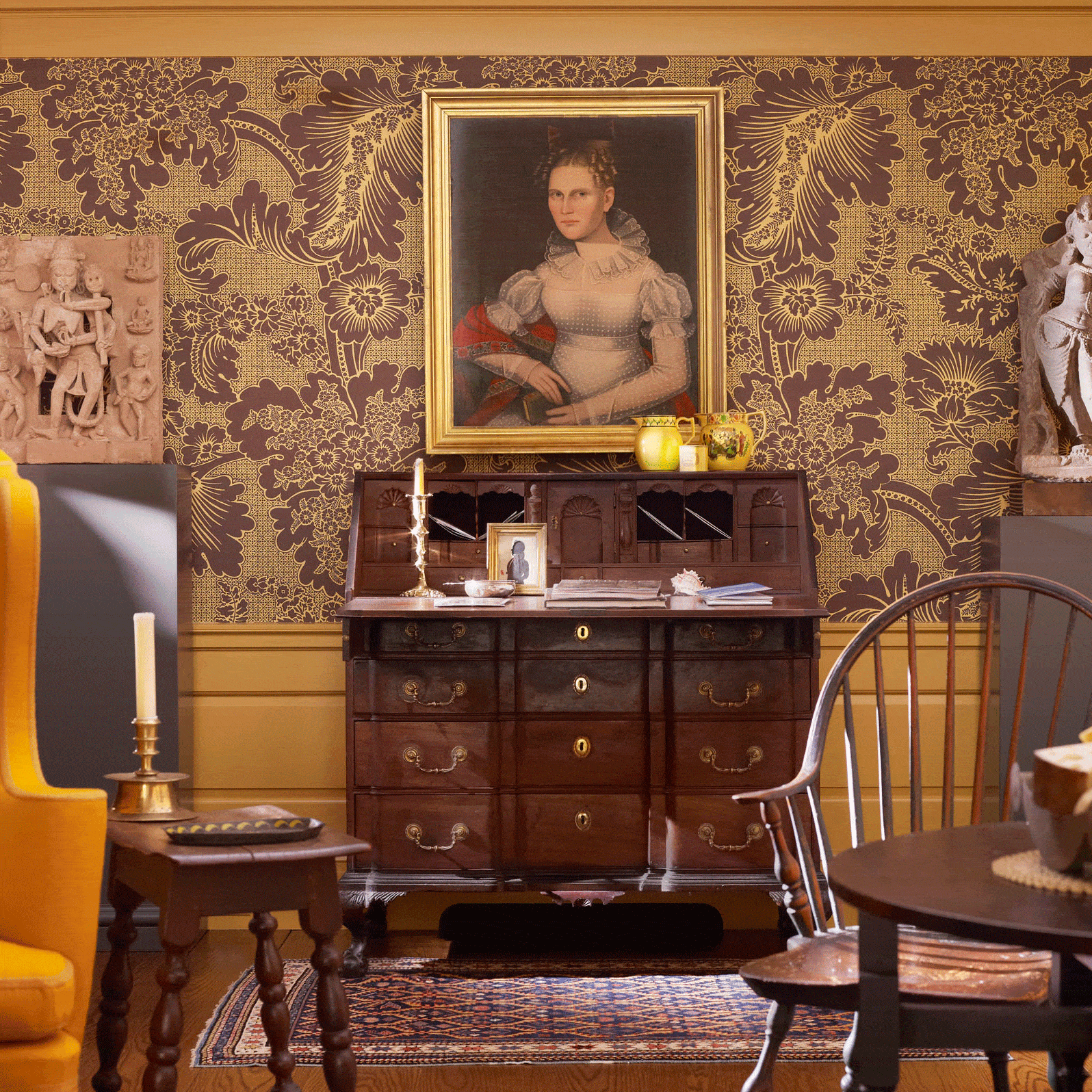 Wallpaper in an eighteenth-century English pattern serves as a background for South Asian sculpture and American antiques.