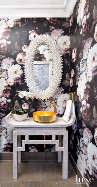 white vanity with black floral wallpaper design and mirror