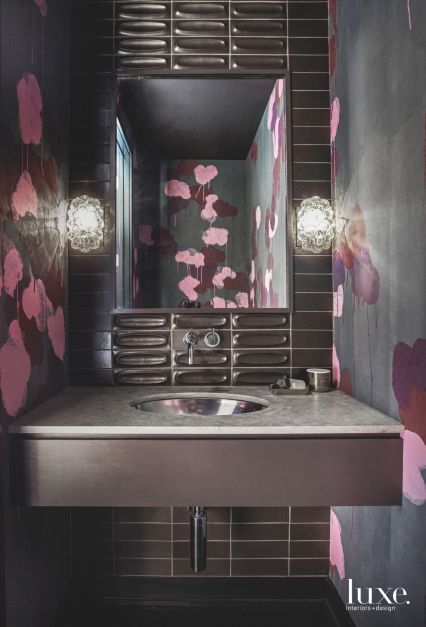 dark moody bathroom with pink and black floral wallpaper and black sink
