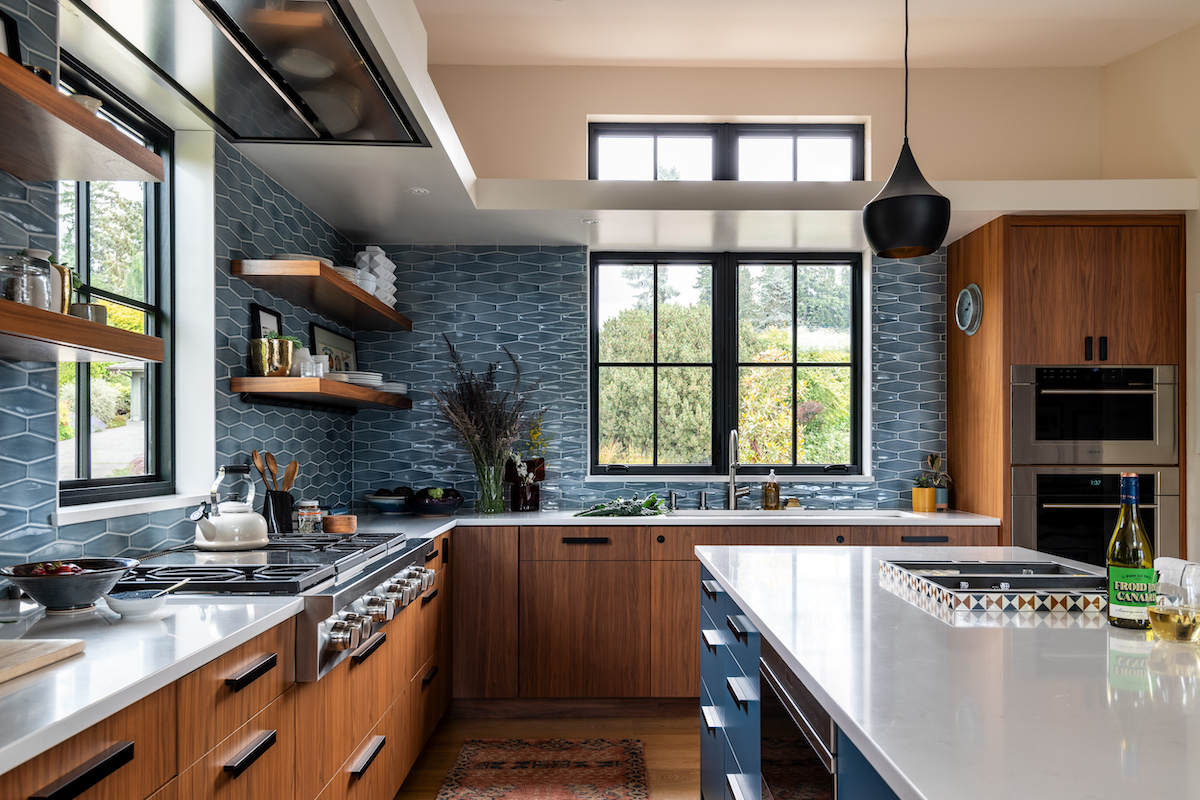 L shaped kitchen with blue tile backsplash.
