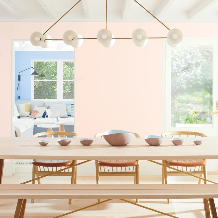 Benjamin Moore's First Light paint in dining space with wooden benches and table