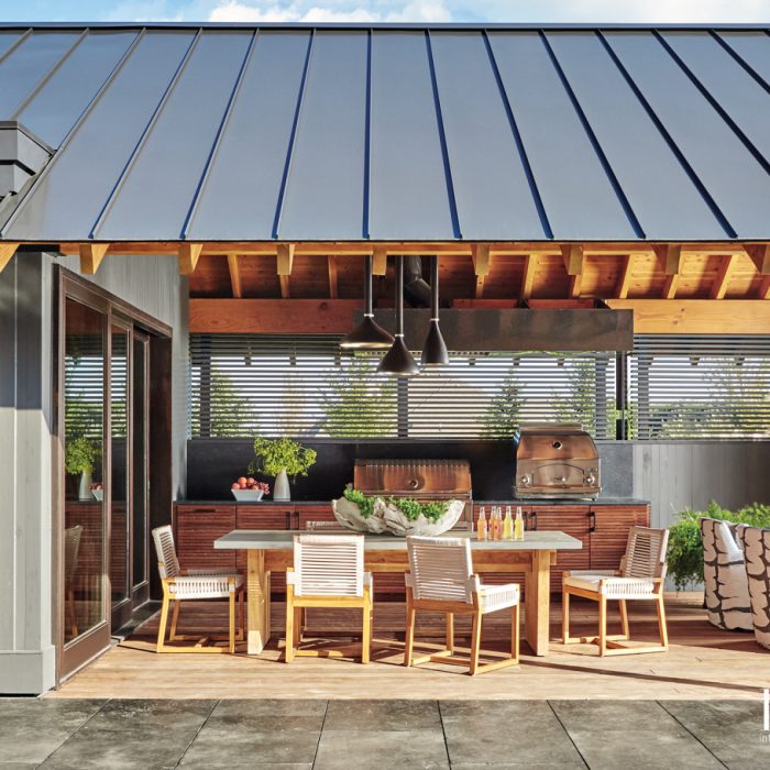 A three-panel door links the breakfast area and covered outdoor dining room, and the spaces share a cedar plank ceiling "for a seamless indoor-outdoor feeling," Knight says. A teak-and-concrete dining table from Clubcu and Palecek teak-and-rope chairs provide just the right place to enjoy some barbecue after a dip in the pool