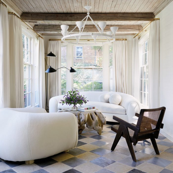 In the sun room, Lonergan added natural textures: Pierre Jeanneret's teak-and-cane armchair, a tree-root coffee table and replicas of Jean RoyÃ¨re's iconic polar bear sofa and chair from M Naeve. The hand-molded plaster chandelier is Stephen Antonson; the Serge Mouille three-arm floor lamp is from Design Within Reach.