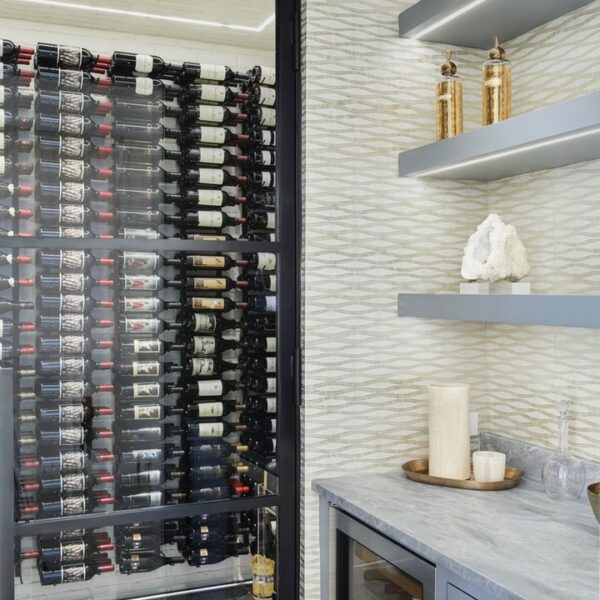 wine room and rack next to wet bar with floating shelves