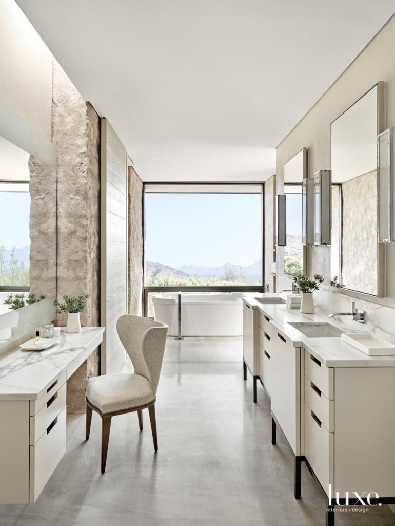 In the airy, open master bath, Biegner's layout achieves a sense of privacy without sacrificing views. The Duravit bathtub and double vanity and the upholstered Kerry Joyce side chair contribute to the sleek, modern aesthetic.