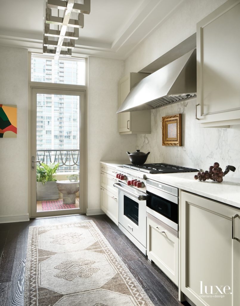 Svenstrup put a fresh twist on the existing kitchen, choosing a Schumacher wallcovering, a vintage Turkish rug and art from South Loop Loft above the oven to enliven the space. "The goal was to enhance the existing finishes and features of the unit," notes the designer.