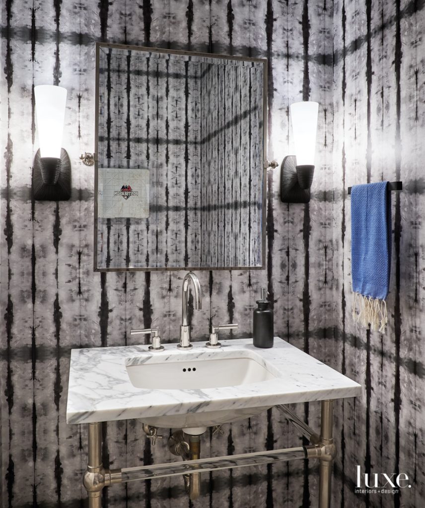 It's a Cubs bathroom without having to be blue," Svenstrup notes of the powder room. Reflected in the mirror is a base from the team's 2016 post-season run. It's set against a Shibori wallcovering that echoes the diamond pattern on the base. The Kelly Wearstler sconces are from Circa Lighting.