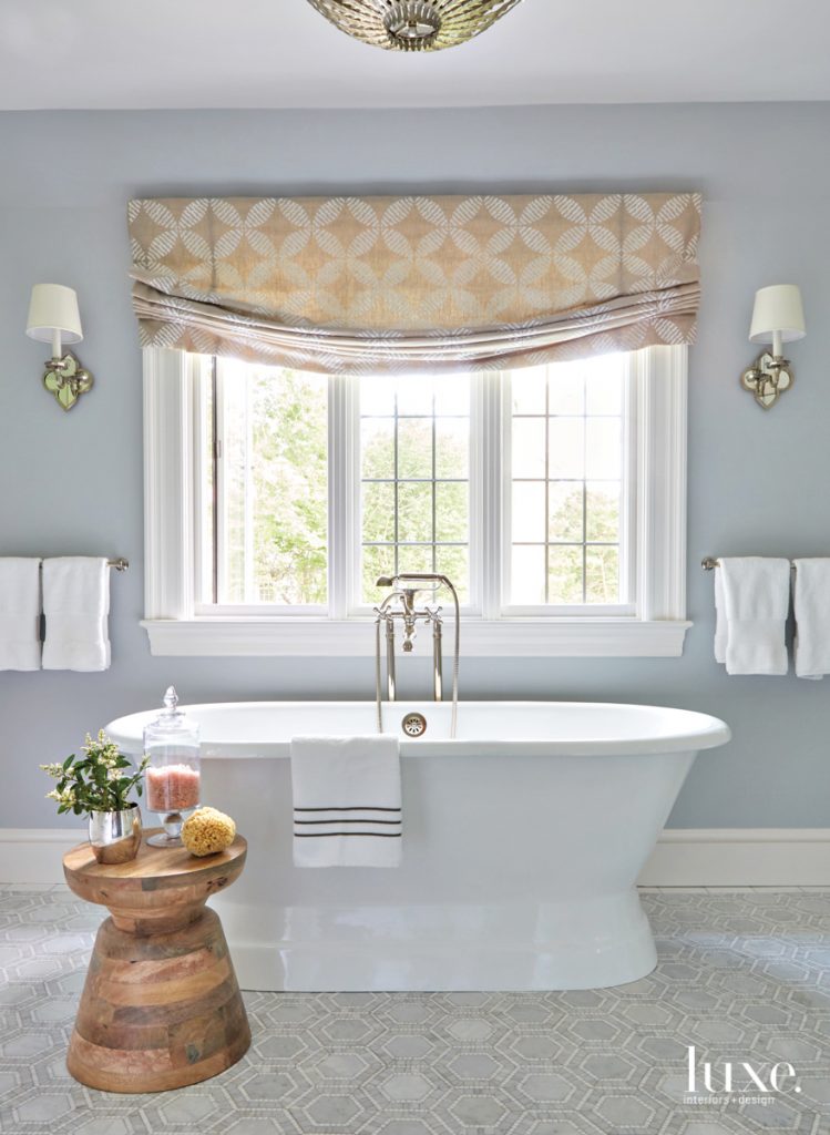 General contractors Arthur C. Lange and Nick Koutoulas worked with Alex to reconfigure the layout of the master bathroom, where a Barclay Cromwell cast-iron bathtub takes center stage. Nova lynx marble from TileBar covers the floor, while a Roman shade made from Thibaut fabric dresses the window.