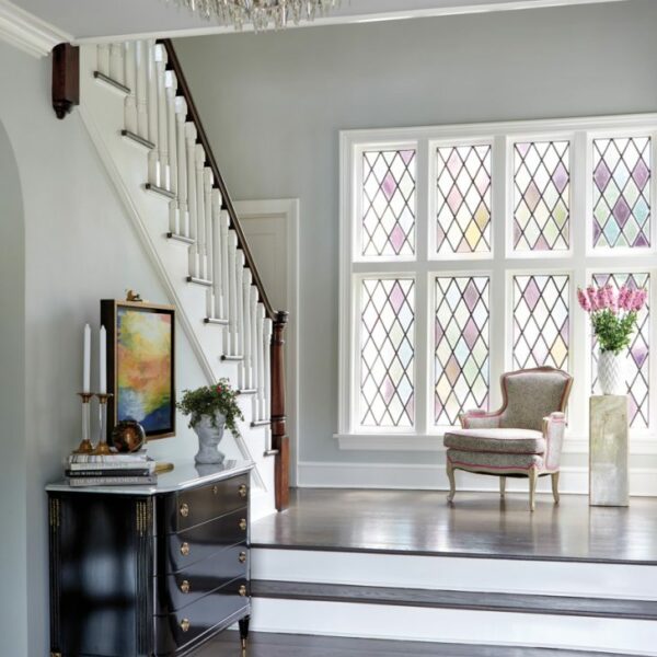Inside A Transformed 1926 New York Tudor That Celebrates Architecture And Character The homeowners were drawn to the original stained-glass window in the foyer of the home, as the husband’s mother had been a stained-glass artist. "It was very close to their hearts," says designer Rajni Alex. A vintage animal-print chair plays off of the window’s pastel tones, and a Visual Comfort chandelier adds a touch of glamour.
