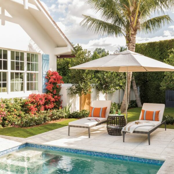 The Cheery Palm Beach Vacation Home You’ll Want To Winter In exterior pool with lounge chairs and umbrella