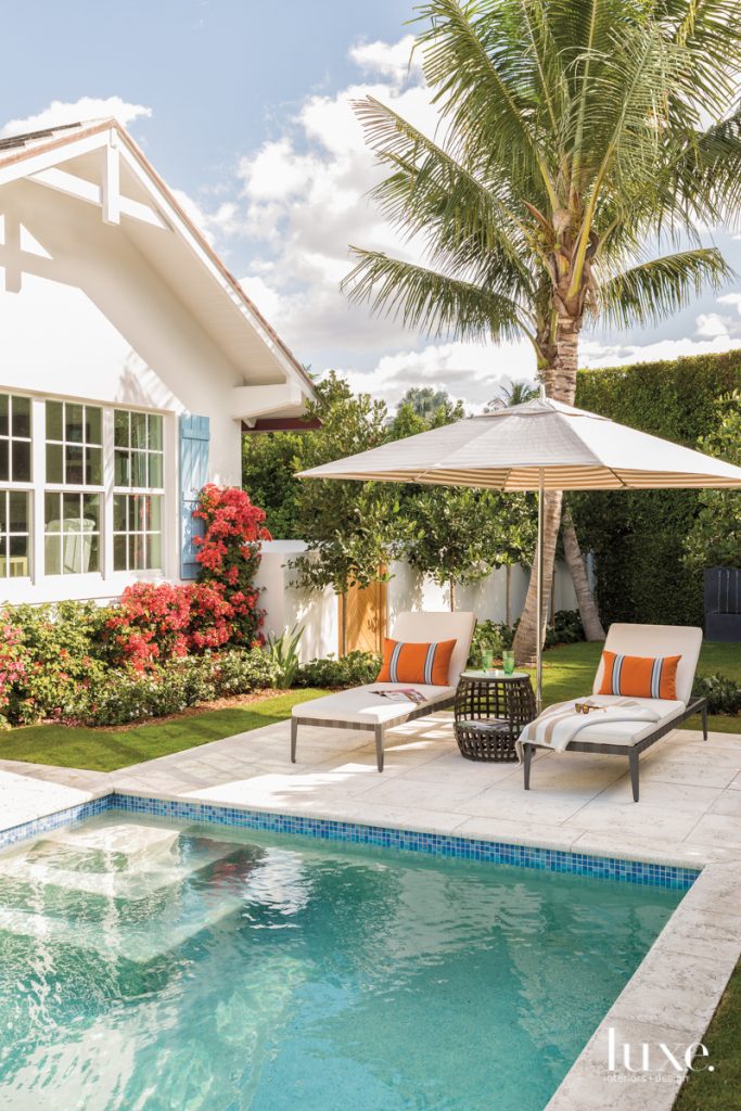 exterior pool with lounge chairs and umbrella