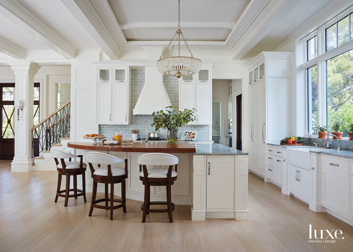 white kitchen with gray-green backsplash and walnut countertop