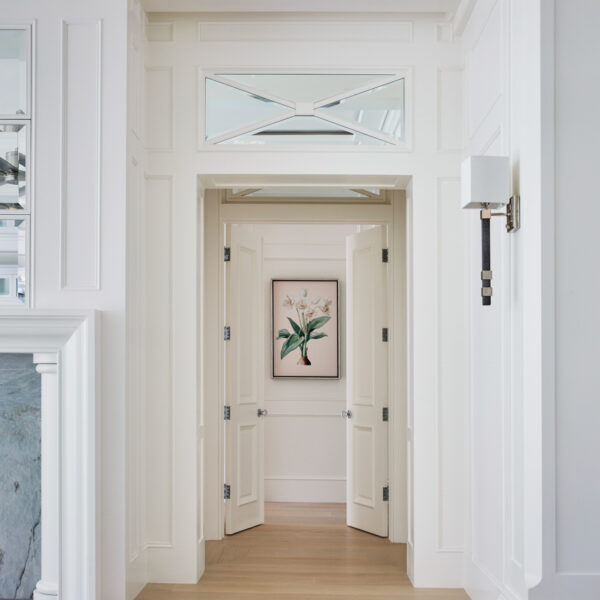 A Breezy Lanai Makes It Easy To Embrace Year-Round Sunshine hallway double doors with faux shagreen-wrapped sconce and polished nickel lights