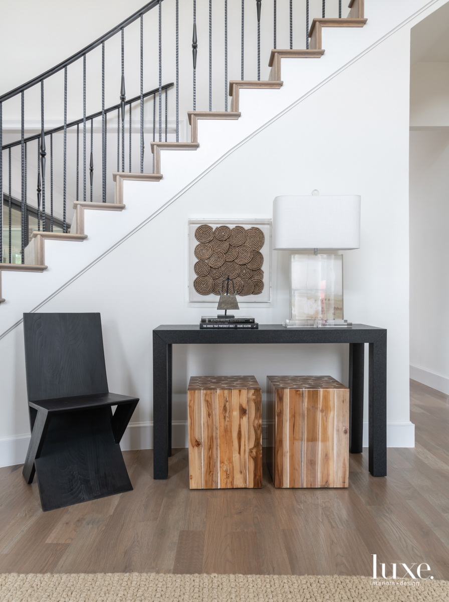 black console table and chair by staircase