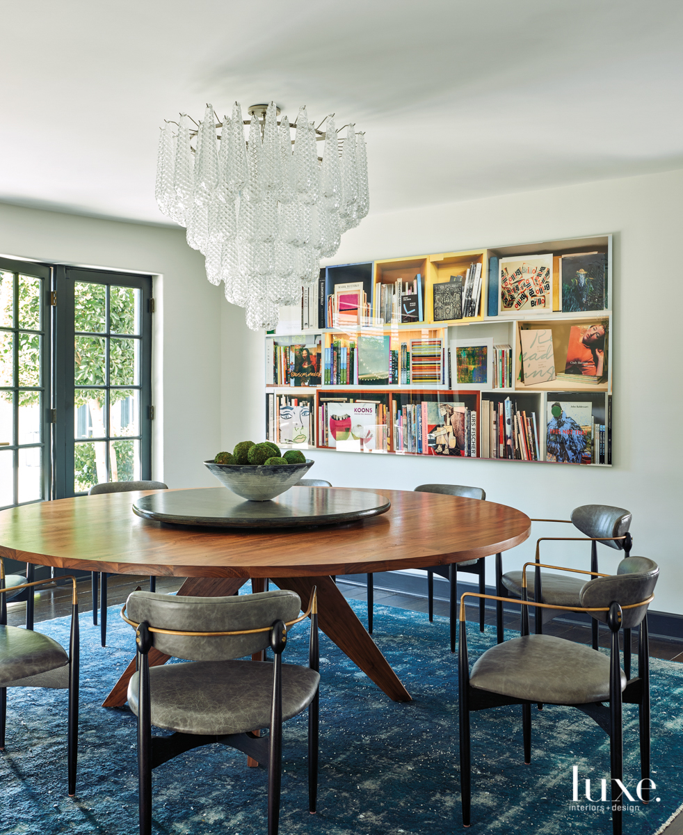 dining room with a round table and grey armchairs and chandelier