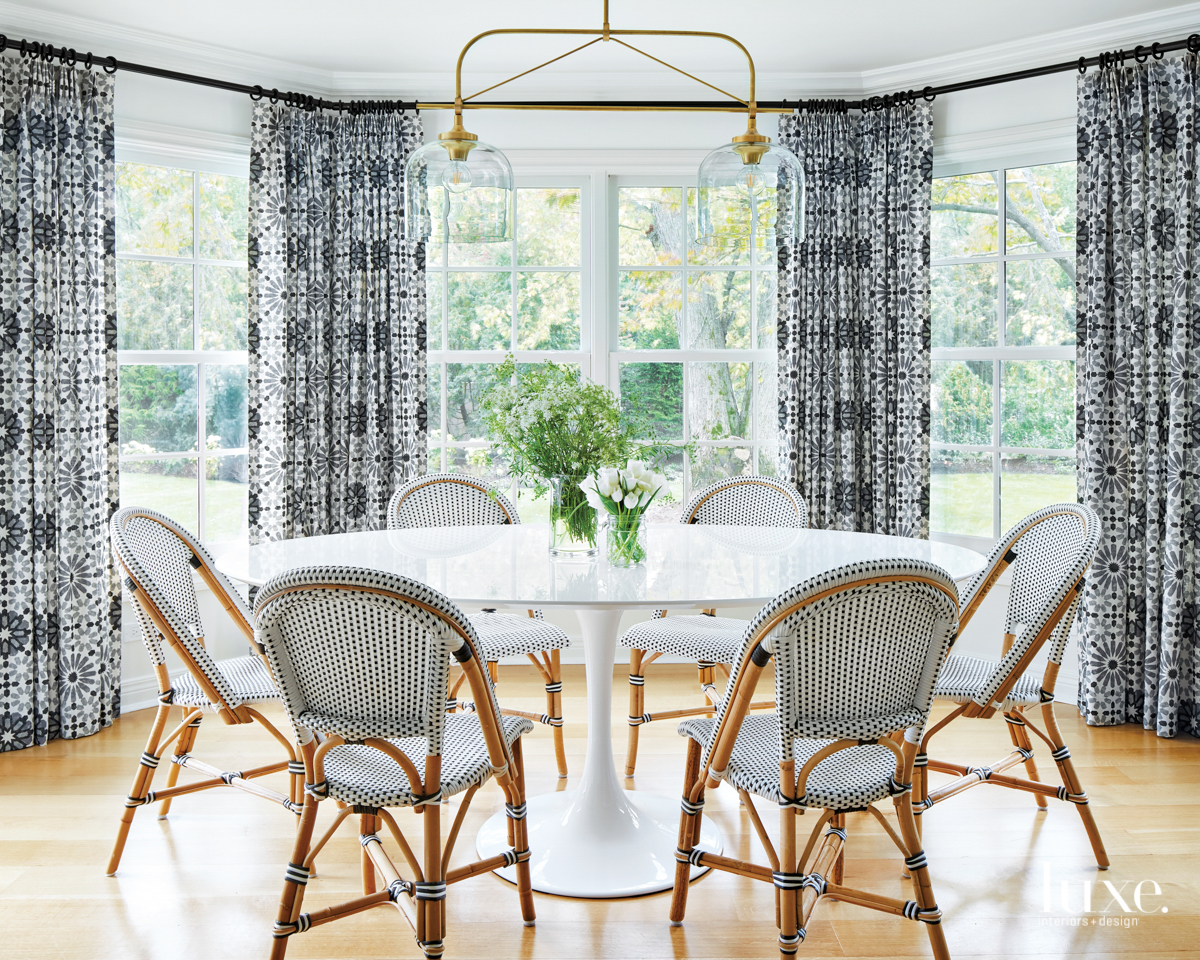 The breakfast nook has rattan chairs and bold printed draperies.