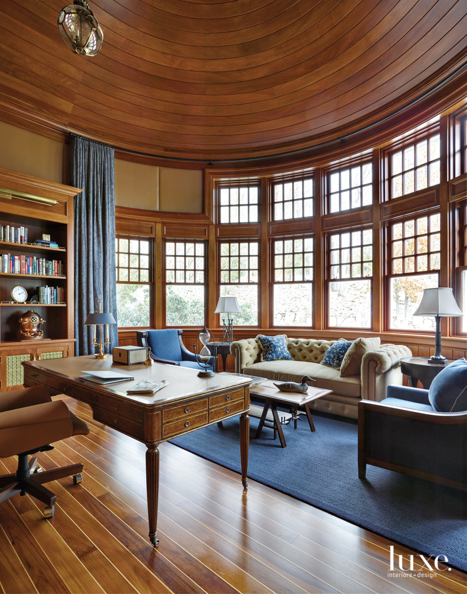 The circular office has a leather walls, a circular ceiling and a walnut desk.