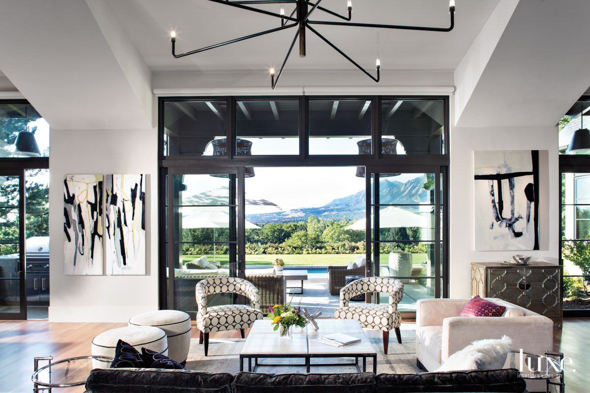 A living room features oversize sliding doors and a mountain view.