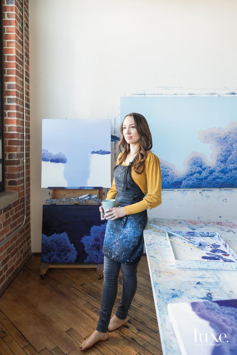The artist in her studio, surrounded by her paintings.