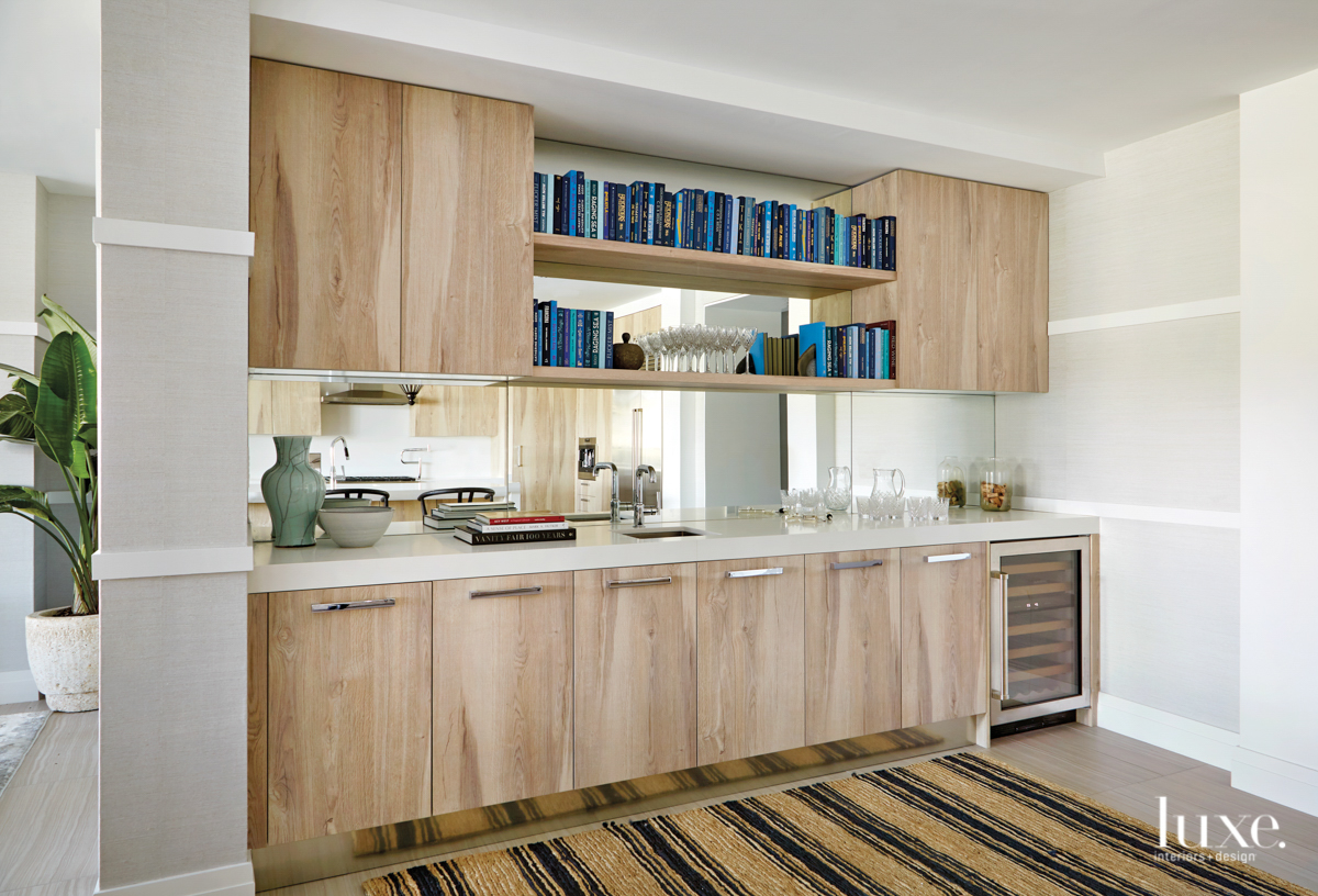 bar with cabinetry and a lined rug with multiple blue books