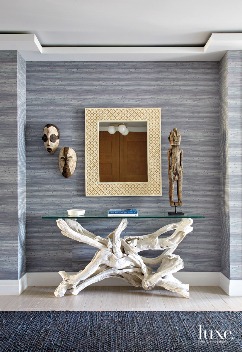 corridor with tribal masks and sculptures held up by a coral inspired table