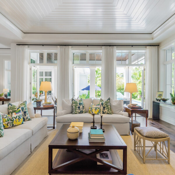 Why Choose Just One? This Florida Home Mixes Tropical Style With Southern Charm living room with two sectionals, tongue-and-groove wood-plank ceiling and a tan rug