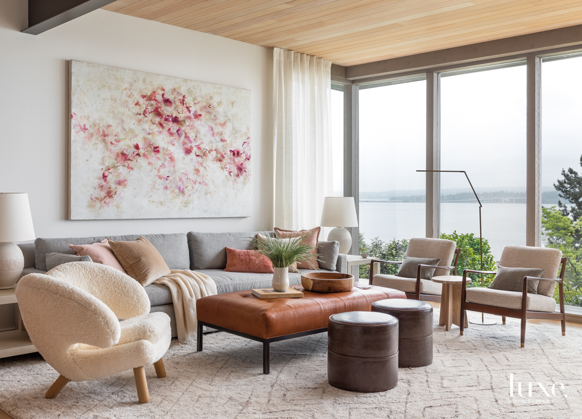 living room with white and pink art piece, sectional and chairs