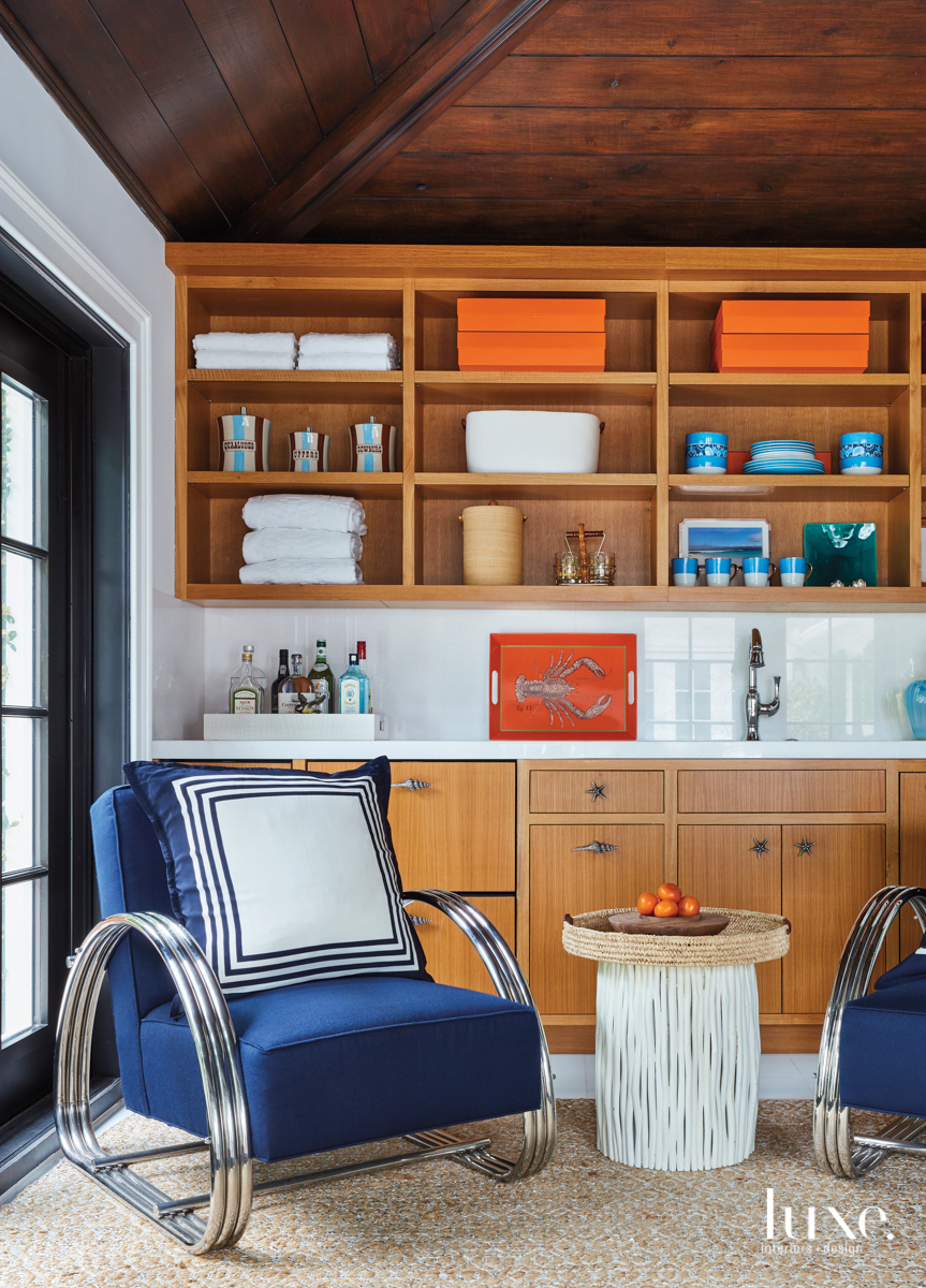 oak tongue-and-groove ceiling panel with a wet bar and blue arm chairs
