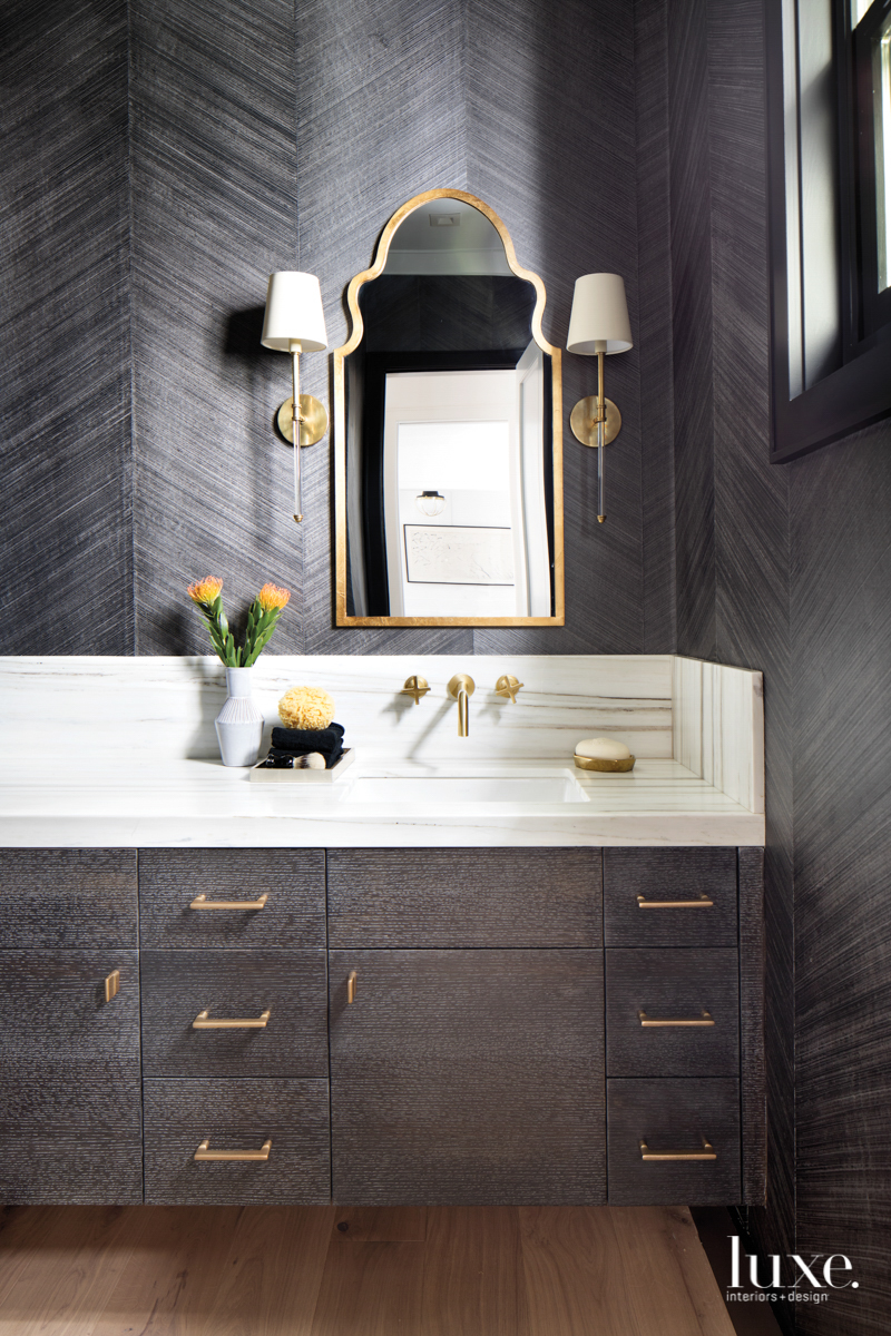 bathroom with charcoal gray wallpaper and marble countertops