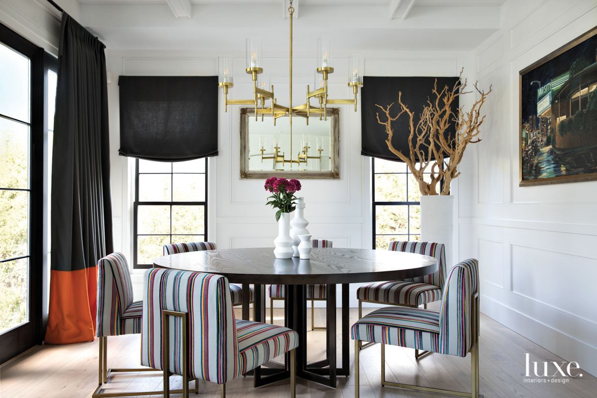 dining room with striped velvet fabric chairs and dark window treatments and white oak floors