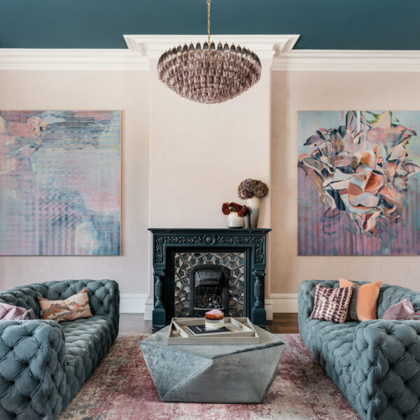 The SF Grand Victorian That Proves Honoring History Still Saves Room For Plenty Of Personality sitting area with blue ceiling and blue couches with art on walls