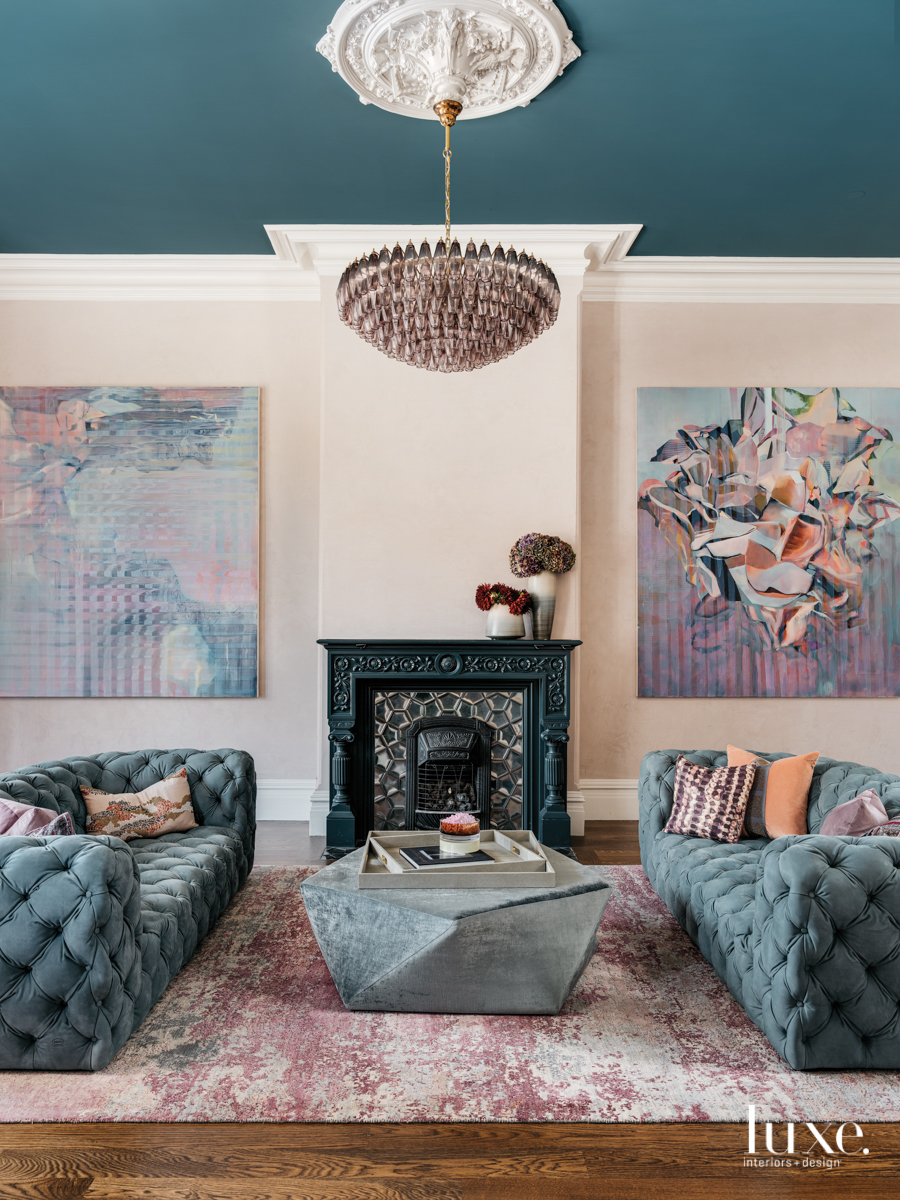 sitting area with blue ceiling and blue couches with art on walls