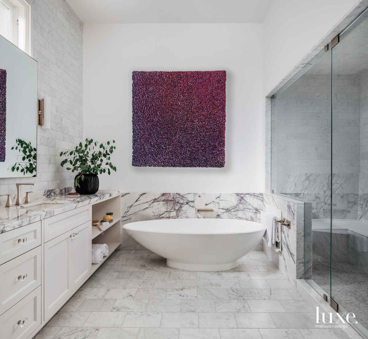 bathroom with stand alone tub and pink and purple art above bath