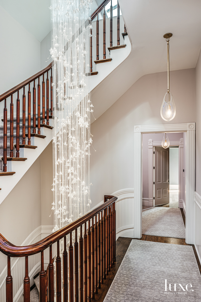 staircase with view of the hall and light fixture hanging between floors