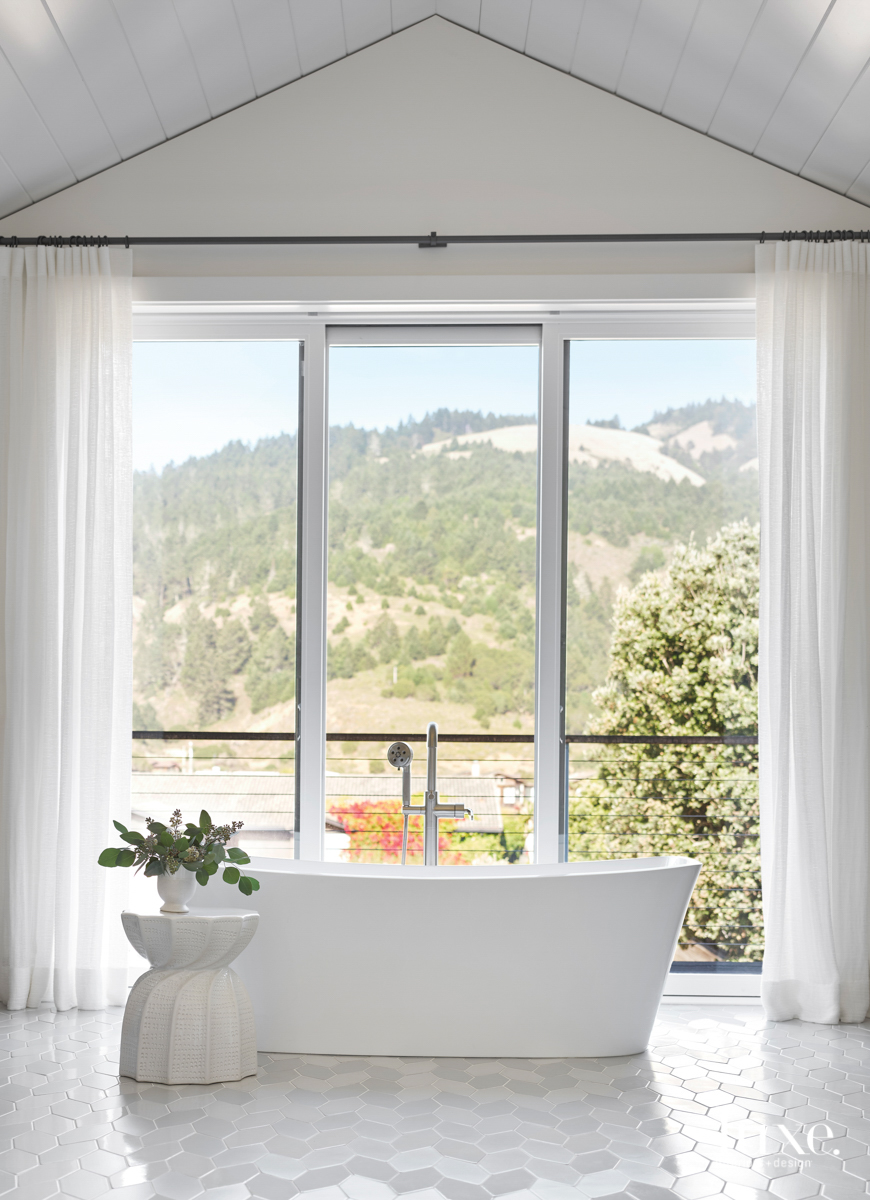 A large bathtub is placed in front of a window wall. Outside, the Marin County, California, mountains are visible.